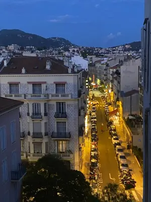 a view of a city street at night with cars parked at La casa in Nice
