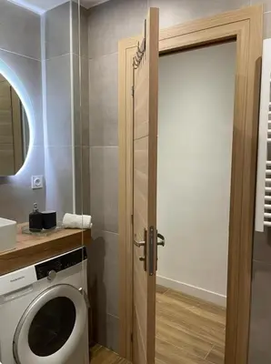 a bathroom with a washing machine and a door at Jolie studio in Nice
