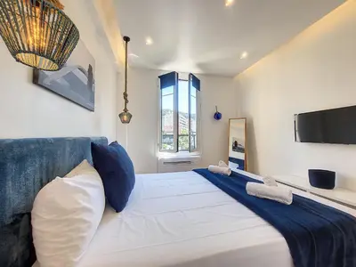 a bedroom with a large white bed with blue and white pillows at Nestor&Jeeves - L ANCRE - Port Area - Close Old Town in Nice