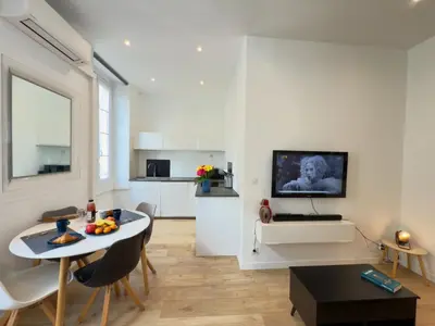 a white living room with a table and a kitchen at Ze Perfect Place - Chic & Cosy au Port Nice - AC in Nice