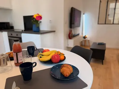 a table with plates of fruit and croissants on it at Ze Perfect Place - Chic & Cosy au Port Nice - AC in Nice