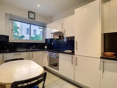 a kitchen with white cabinets and a table and a window at Nestor&Jeeves - L'OLYMPIC - Central - Very close sea in Nice