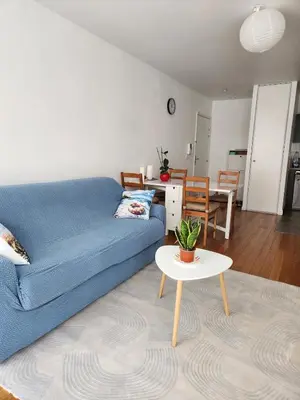 a living room with a blue couch and a table at Charmant 2 pièces, centre ville & proche gare in Nice