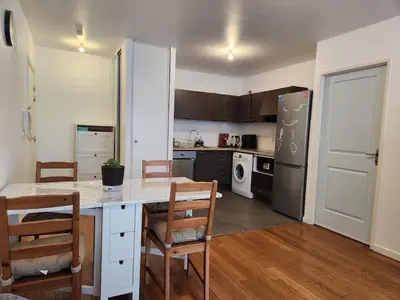 a kitchen with a table and chairs and a refrigerator at Charmant 2 pièces, centre ville & proche gare in Nice