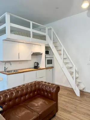 a living room with a couch and a staircase at Appartement central in Nice