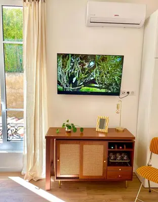 a living room with a flat screen tv on a wall at Under the Citrus Trees in Nice