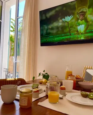 a dining room table with food and a television on the wall at Under the Citrus Trees in Nice