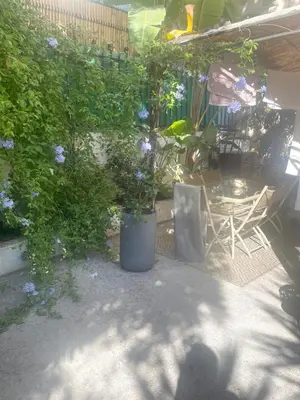 a patio with chairs and a tree and flowers at Appartment with private garden in city center Nice in Nice