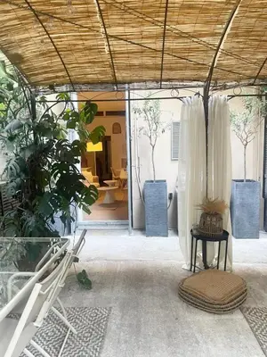 a room with a bed and a table and a room with trees at Appartment with private garden in city center Nice in Nice