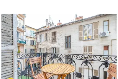 a table and chairs on a balcony of a building at Large Studio 7 minutes from Beach in Nice