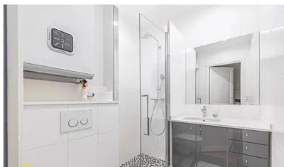a white bathroom with a shower and a sink at Large Studio 7 minutes from Beach in Nice