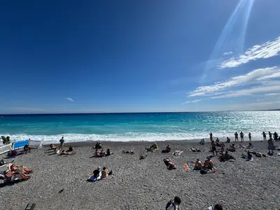 a group of people sitting on a beach at Large Studio 7 minutes from Beach in Nice