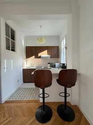 a kitchen with two bar stools in front of a counter at Large Studio 7 minutes from Beach in Nice
