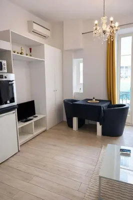 a kitchen with white cabinets and a sink at Appartement central avec balcon in Nice