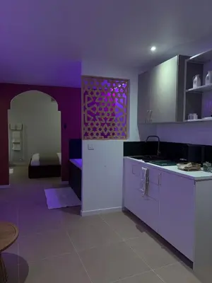 a purple kitchen with a sink and a table at Suite orientale avec baignoire balnéo in Cagnes-sur-Mer