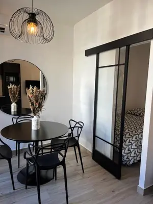 a dining room with a table and chairs and a mirror at Charmant 2 pièces - Hyper Centre de Nice in Nice