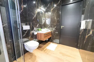 a bathroom with a toilet and a sink at Romantic suite with jacuzzi in La Trinité