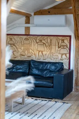 a black leather couch in a room with a wall at Appart' cosy sur les toits du coeur de Nice - Clim in Nice