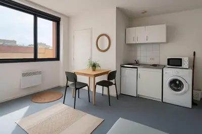 a kitchen with a table and a washing machine at Bright studio in Nice - Mobility lease only - WIFI in Nice