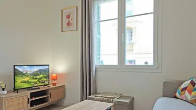 a living room with a tv and a window at LX148 Charmant studio renove Tram - Bail mobilite in Nice