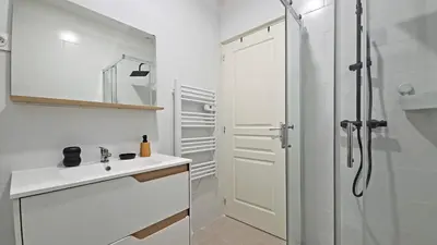 a white bathroom with a shower and a sink at LX149 Studio lumineux fonctionnel - Bail mobilite in Nice