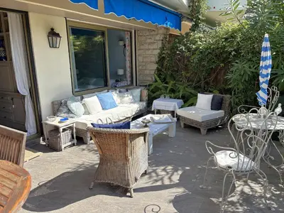 a patio with a couch and a table and chairs at Appartement 2 chambres, terrasses, proche mer et commerces à Saint-Jean Cap Ferrat in Saint-Jean-Cap-Ferrat