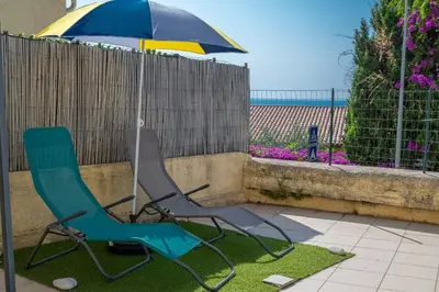 two chairs and an umbrella next to a fence at louna in Beaulieu-sur-Mer