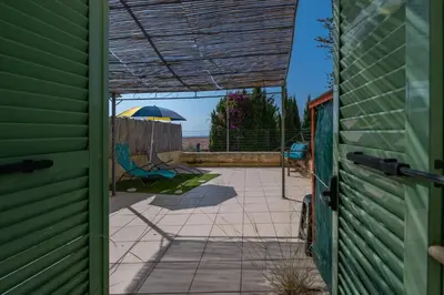 an open door to a patio with an umbrella at louna in Beaulieu-sur-Mer