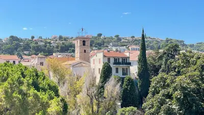a building on the side of a hill with trees at Superbe deux pièces dans le vieux village in Saint-Laurent-du-Var