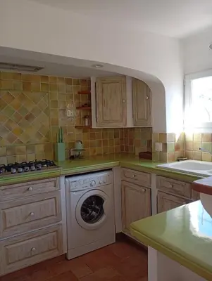 a kitchen with a washing machine in the middle at Bas de villa , coin détente extérieur et parking in Cagnes-sur-Mer