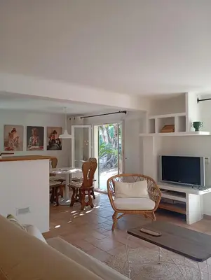 a living room with a couch and a tv at Bas de villa , coin détente extérieur et parking in Cagnes-sur-Mer