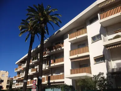 a building with a palm tree in front of it at Studio NICE near the sea in Nice