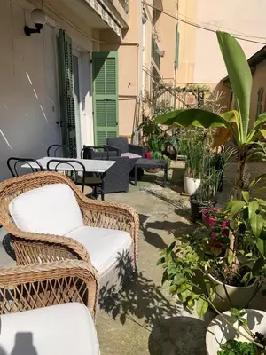 a patio with wicker chairs and tables and plants at Appartement et terrasse Nice centre in Nice