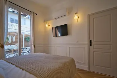 a bedroom with a bed and a tv on the wall at Nice Charm XXL Terrace in Nice
