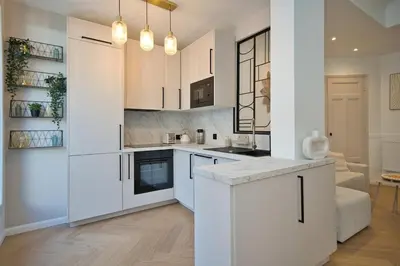 a white kitchen with white cabinets and a table at Nice Charm XXL Terrace in Nice
