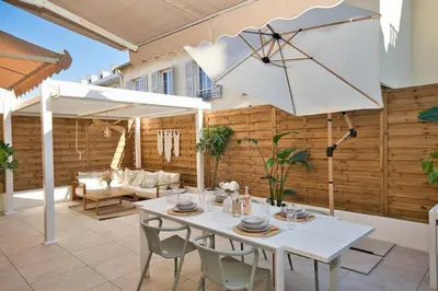 a white table with chairs and an umbrella on a patio at Nice Charm XXL Terrace in Nice