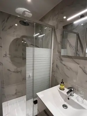 a bathroom with a sink and a glass shower at Bottero nice in Nice