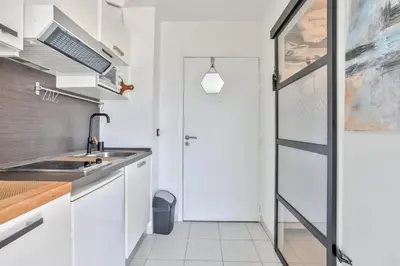 a kitchen with white cabinets and a sink and a door at Heidi Braesch Apartment in Nice