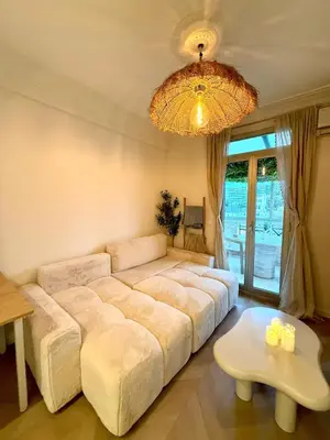 a bedroom with a large bed and a chandelier at Beachfront Appartment Nice Promenade des anglais 2 terraces in Nice