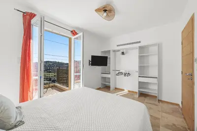 a white bedroom with a bed and a window at Happyfew Domaine des Sources in Nice