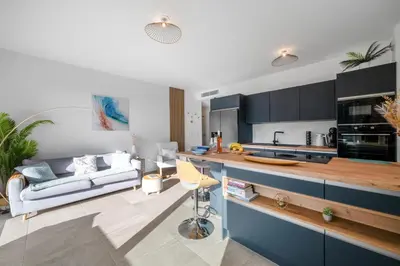 a living room with a couch and a kitchen at Modern Luxury - Sea View over Èze Village in Èze