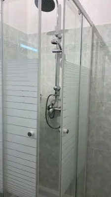 a shower with a glass door in a bathroom at Plein centre, calme et cosy in Nice