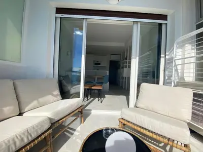 a living room with two white couches and a balcony at mure in Beaulieu-sur-Mer