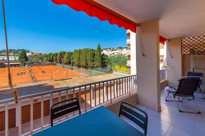 a balcony with a view of a tennis court at fisher in Beaulieu-sur-Mer