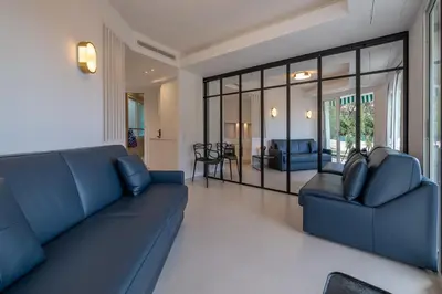 a living room with a blue couch and chairs at Ferreira in Saint-Jean-Cap-Ferrat
