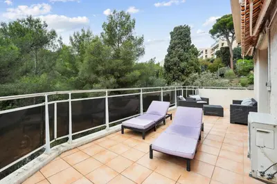 a balcony with a glass table and chairs on a patio at LX173 Studio grande terrasse vue mer tres calme in Nice