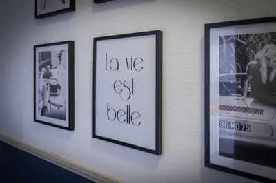 a wall with framed pictures on a wall at Chambre 4 La Nissa Bella in Nice