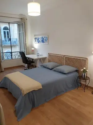 a bedroom with a bed and a desk and a table at Spacious apartment with balcony - Nice center in Nice