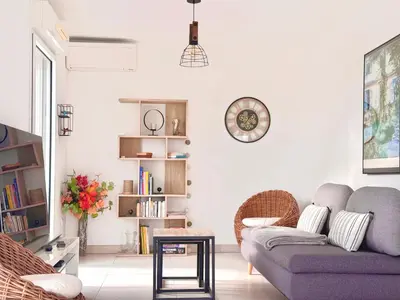 a living room with a couch and a clock on the wall at La Vista Mar - Apt Seaview Near Airport-AC-Parking in Saint-Laurent-du-Var