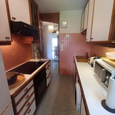 a kitchen with white counters and red tiles at Centre ville de St Jean Cap Ferrat in Saint-Jean-Cap-Ferrat